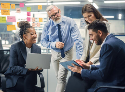 A diverse group of business professionals collaborating in a bright office, discussing ideas and smiling during a meeting