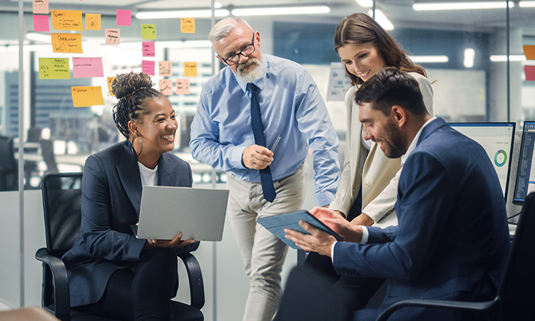 A diverse group of business professionals collaborating in a bright office, discussing ideas and smiling during a meeting